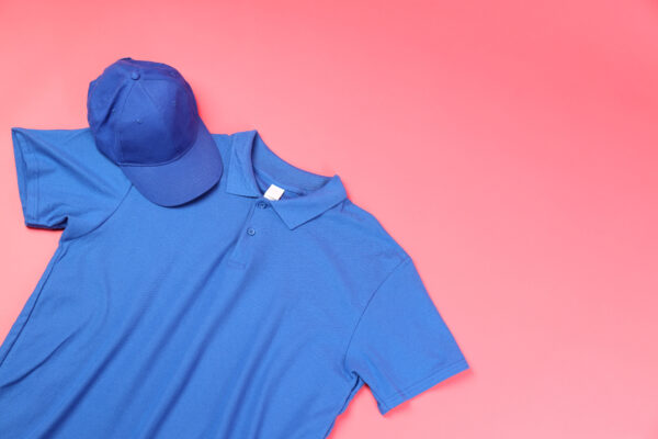 Blank t-shirt and cap on pink background