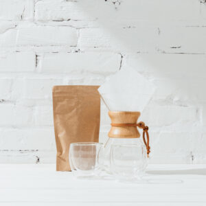 Glass mugs, chemex and paper package with coffee